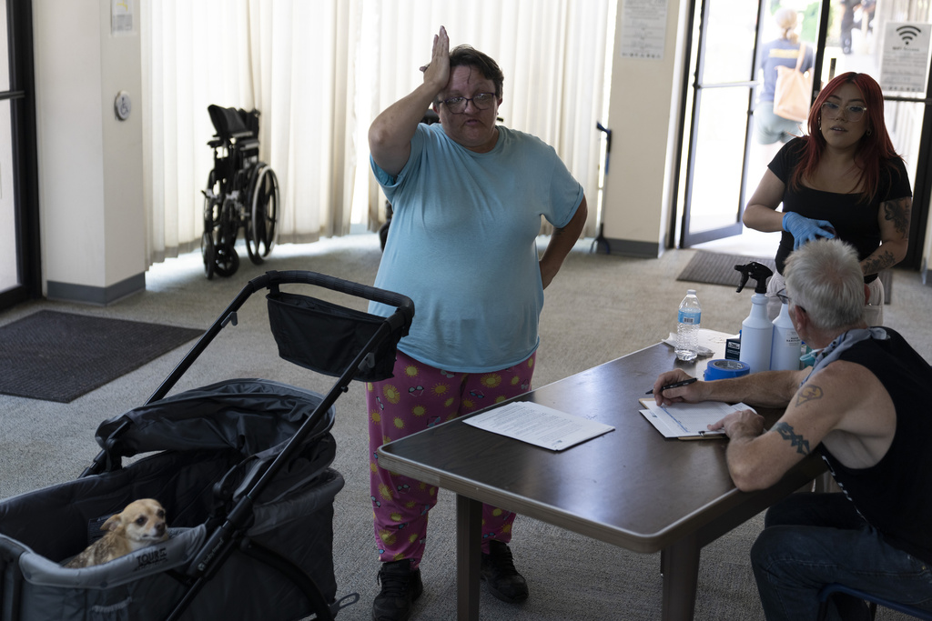 Sherri Thompson, with her chihuahua 14-year-old Kiwahi, arrives at the Cook Plaza cooling center after waiting for the center to open