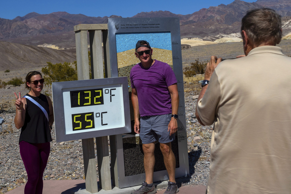 Melissa Bolding and Bryan Bolding from Oklahoma City pose for a photo next to a thermometer displaying a temperature of 132 degrees Fahrenheit / 55 degrees Celsius at the Furnace Creek Visitors Center, in Death Valley National Park, Calif.