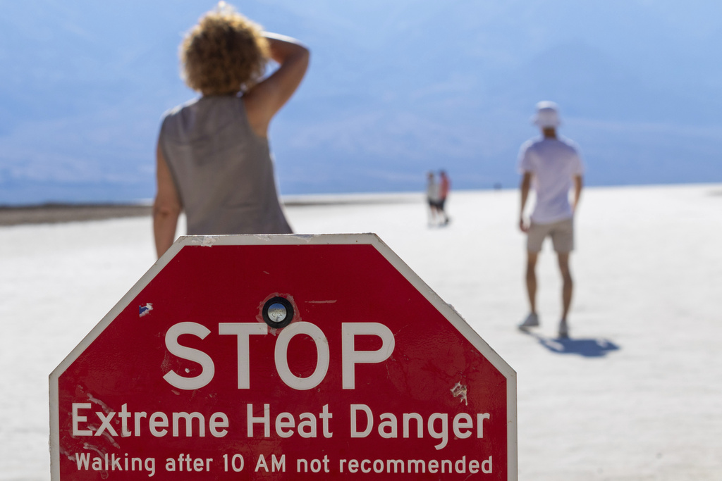 A person wipes sweat from their brow at Badwater Basin in Death Valley National Park, Calif.