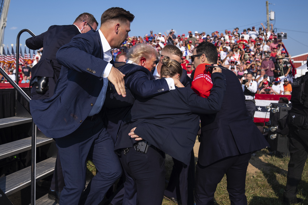 Republican presidential candidate former President Donald Trump is helped off stage by U.S. Secret Service agents