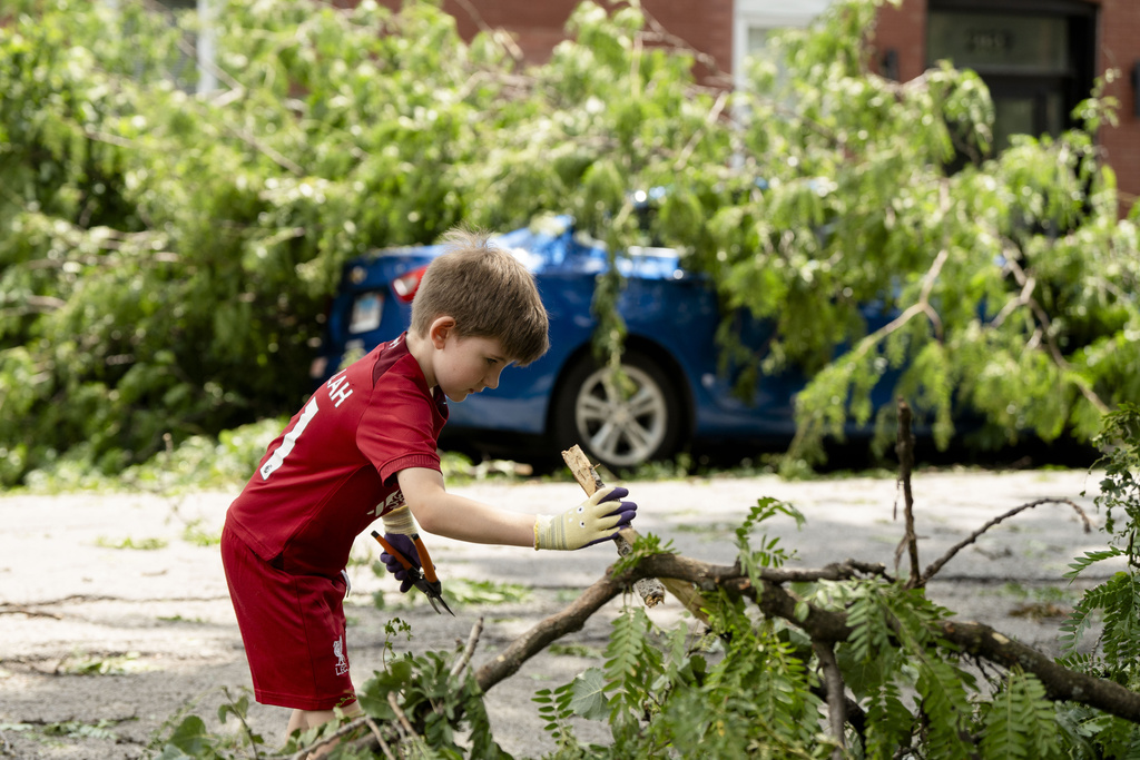 Ezra Solomon, 8, helps clear the road of debris near the intersection of West Huron and North Leavitt Street in Chicagoland