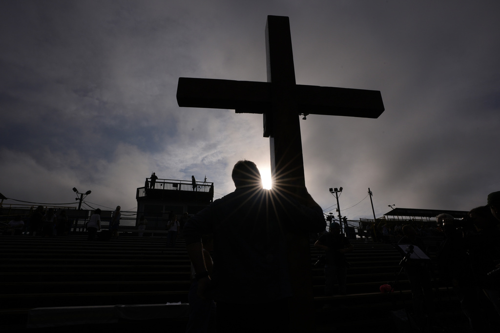 Dan Beazley, of Detroit, holds a cross during a vigil for Corey Comperatore, the former fire chief who shielded his family from shooter