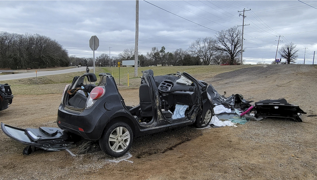 Heavily damaged vehicle is seen off a road in Tishomingo, Okla., following a two-vehicle collision in which six teenage students were killed