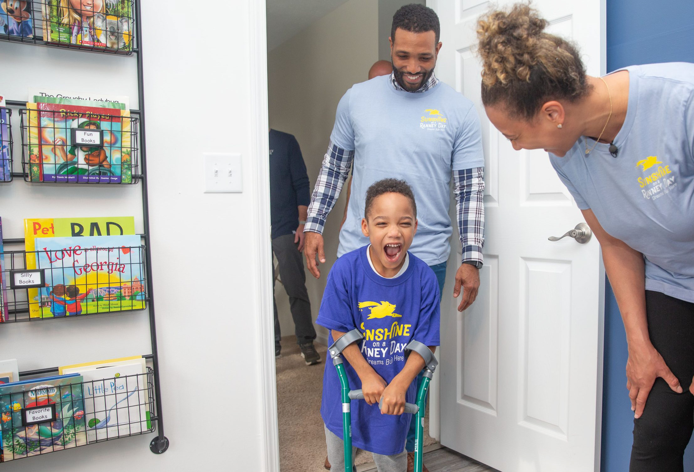 Little boy seeing his new bedroom with his parents