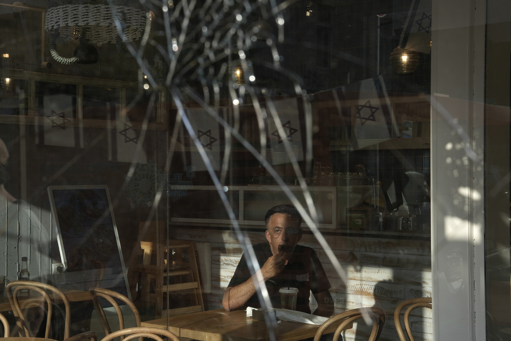 A man eats breakfast in a cafe near the scene of a deadly explosion in Tel Aviv