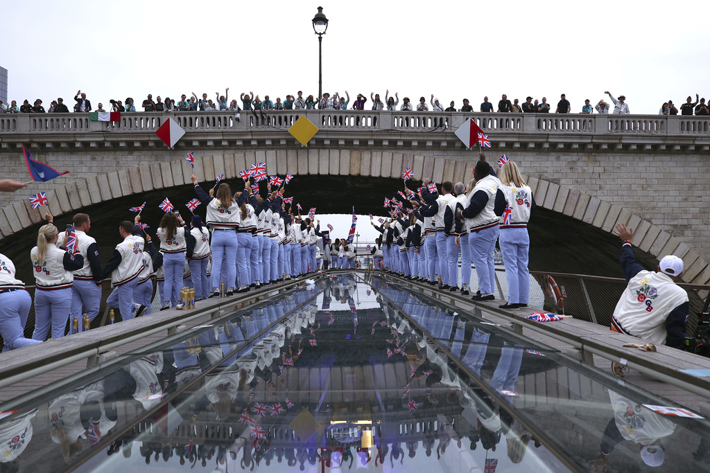 Spectators cheer as Great Britain athletes pass under a bridge along the Seine River during the opening ceremony for the 2024 Summer Olympics in Paris