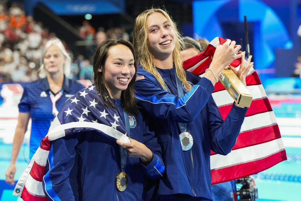 Gold medalist, Torri Huske, left, of the United States, walks with silver medalist, Gretchen Walsh, of the United States, after the women