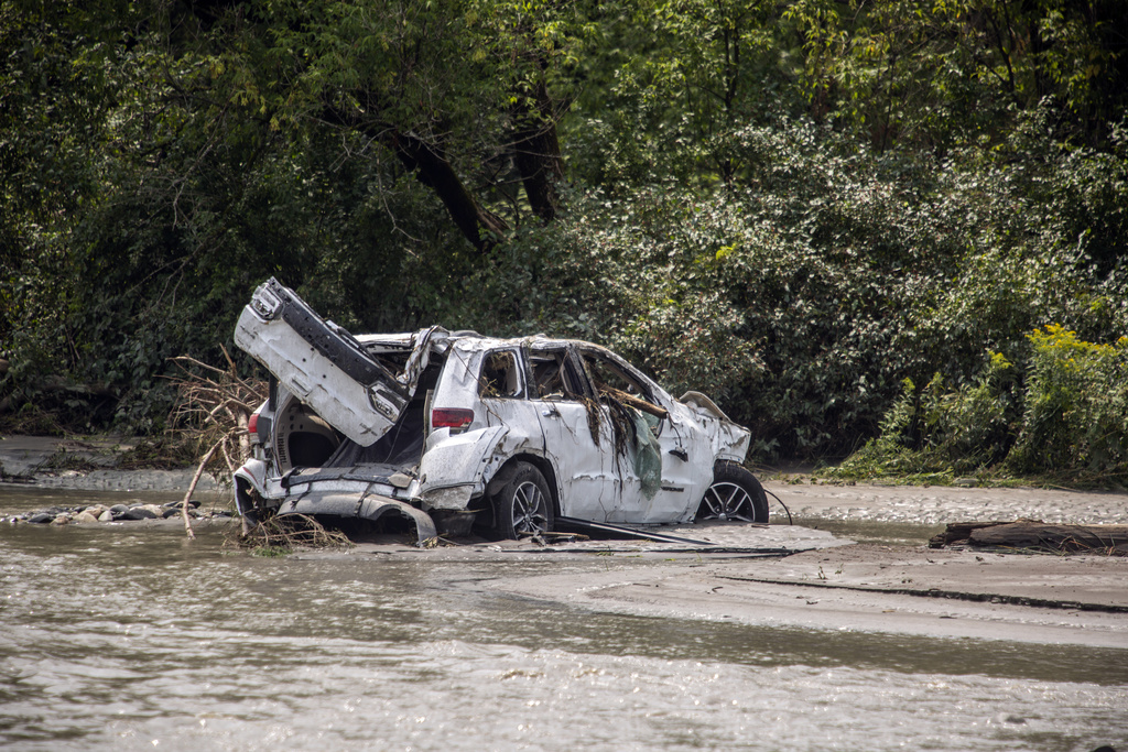 A damaged car sits amid flood debris in Lyndon, Vt.