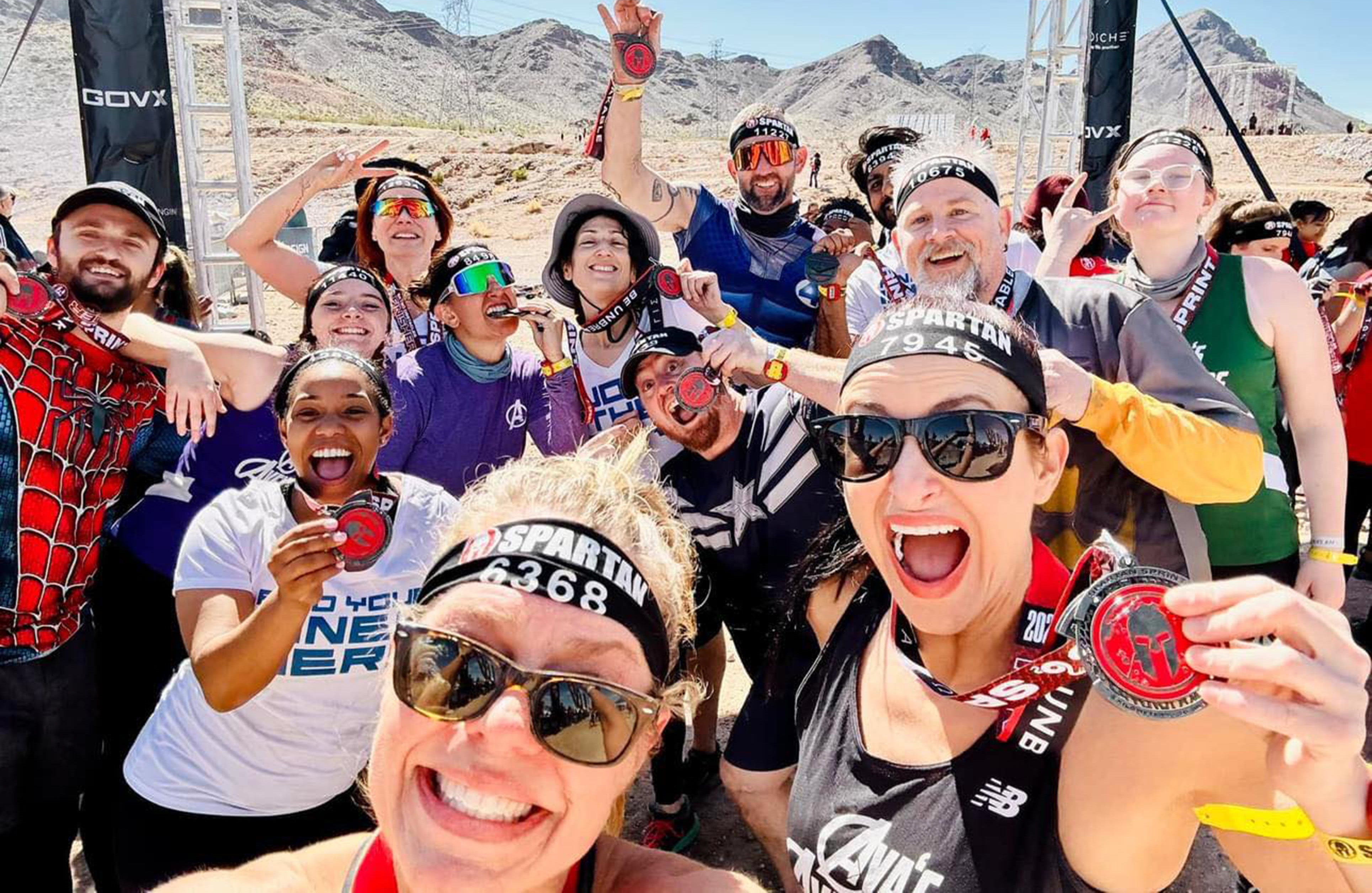 15 people holding up their spartan medal 