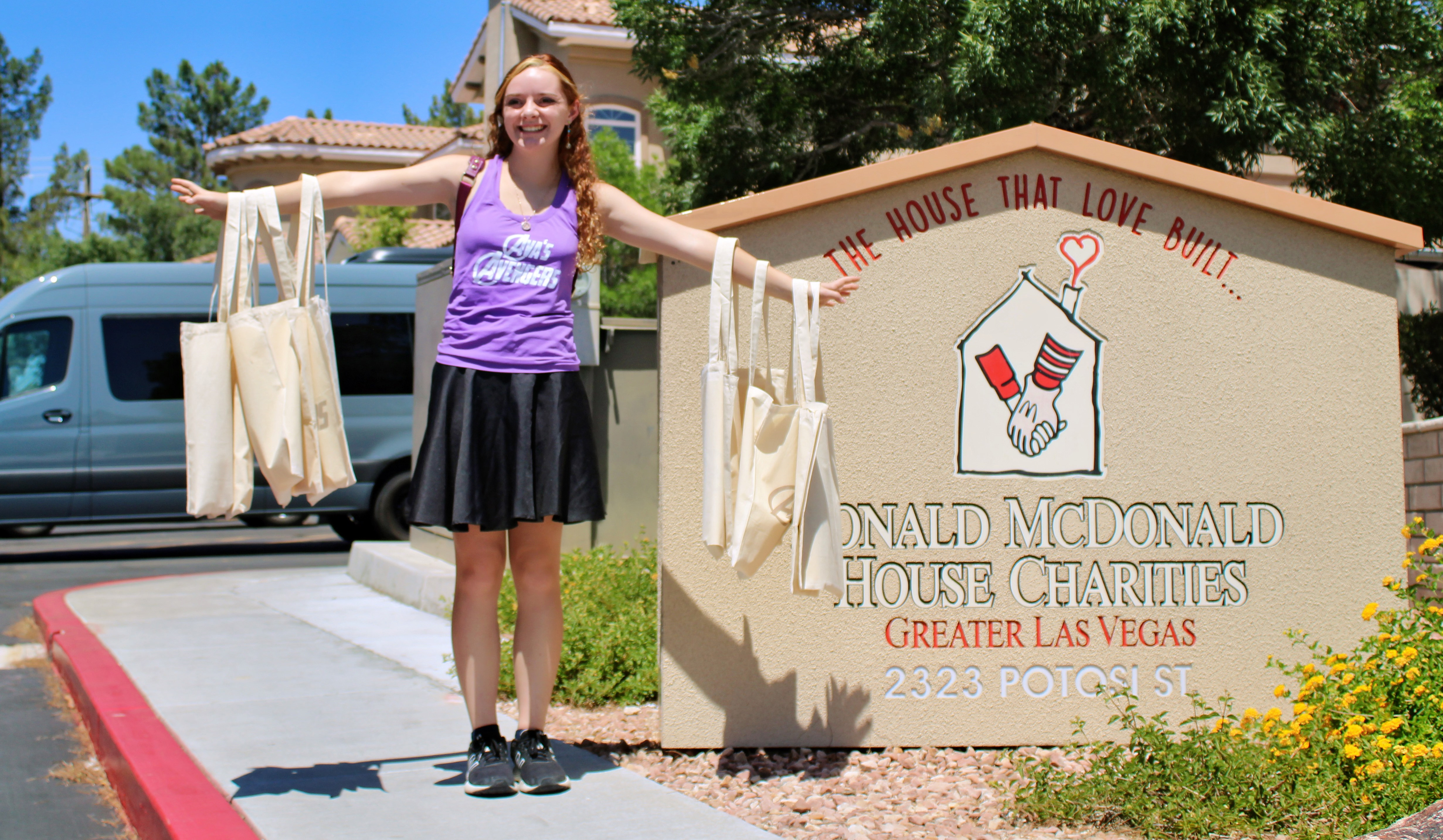 Girl holding tote bags outside of Ronald McDonald House