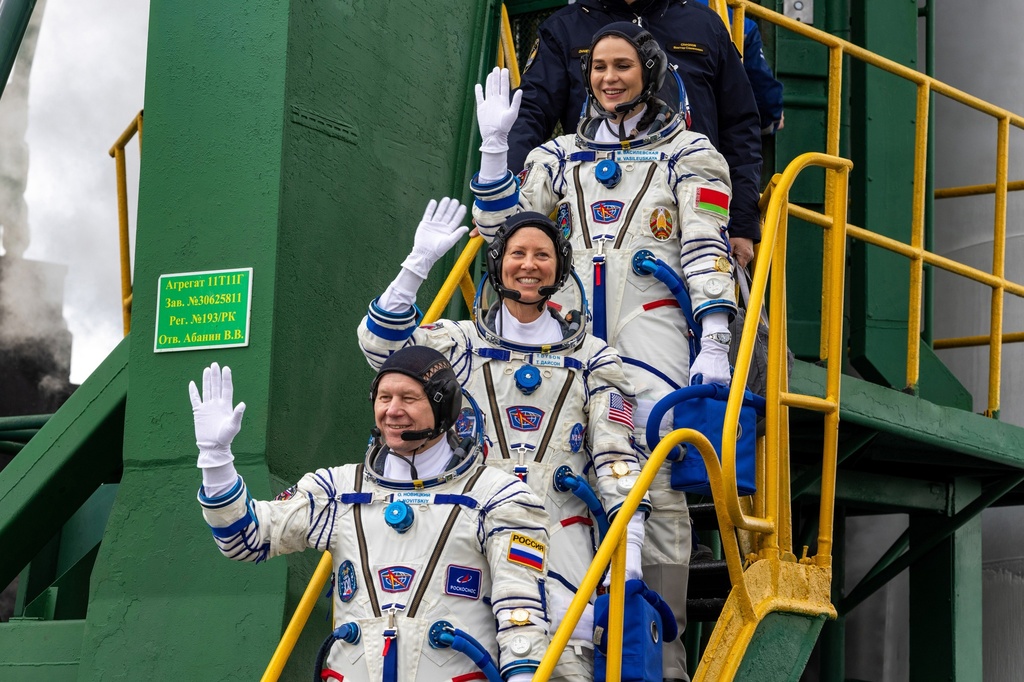 NASA astronaut Tracy Dyson, centre, Oleg Novitsky of Roscosmos, bottom, and Marina Vasilevskaya of Belarus wave as they board to the space ship at the Russian leased Baikonur cosmodrome