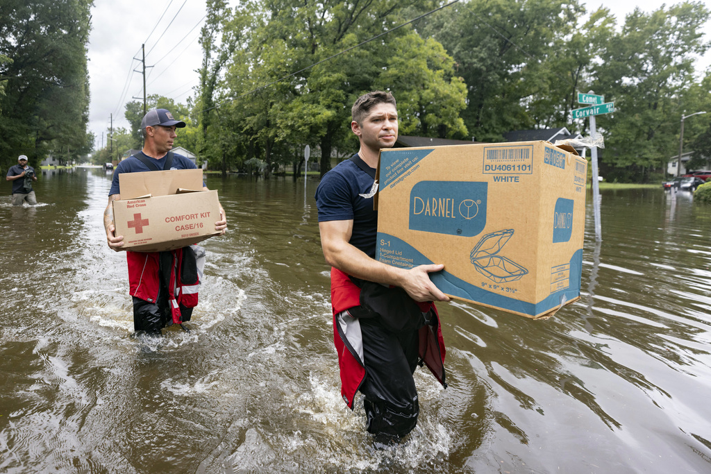 Savannah Fire Advanced Firefighters Ron Strauss, right, and Andrew Stevenson, left, carry food to residents in the Tremont Park neighborhood that where stranded in flooding from Tropical Storm Debby