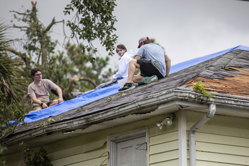 Residents repair their roof as high winds from an outer band from Tropical Storm Debby passed over the Isle of Palms, S.C., Tuesday, Aug. 6, 2024.