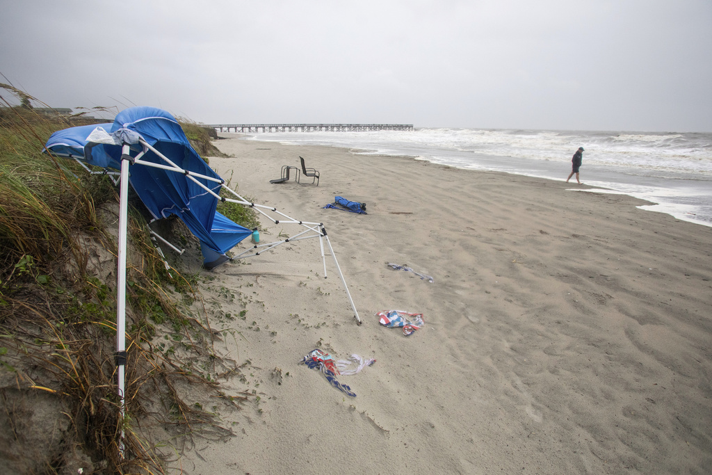 A person walks on a windy and rainy beach as Tropical Storm Debby approaches the area, Tuesday, Aug. 6, 2024, in Isle of Palms, S.C.