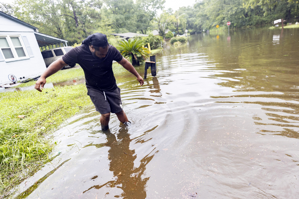 Tremont Park Joe Farley tests the depth of the water in his West Savannah neighborhood after stormwater from Tropical Storm Debby flooded his street with up to three feet of water, Tuesday, Aug. 6, 2024, in Savannah, Ga.