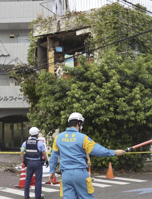 People take shelter outside building following an earthquake in Miyazaki, western Japan, Thursday, Aug. 8, 2024.