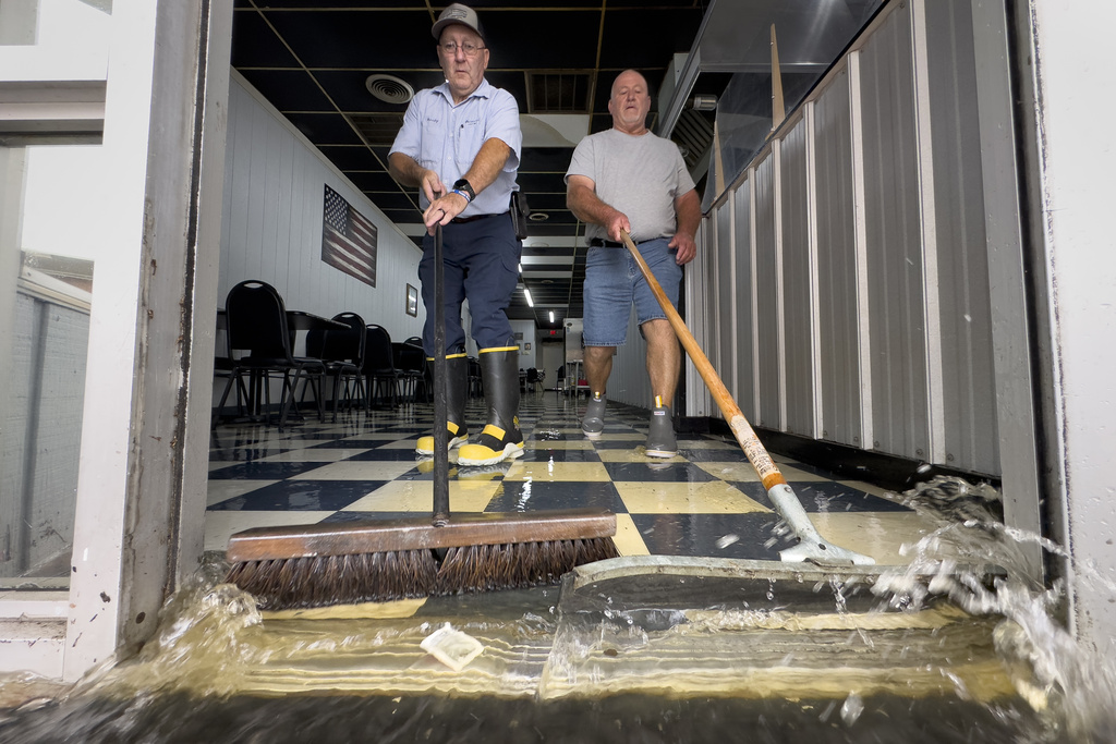 Randy Sikes, left, brooms water out of Diamond Dave