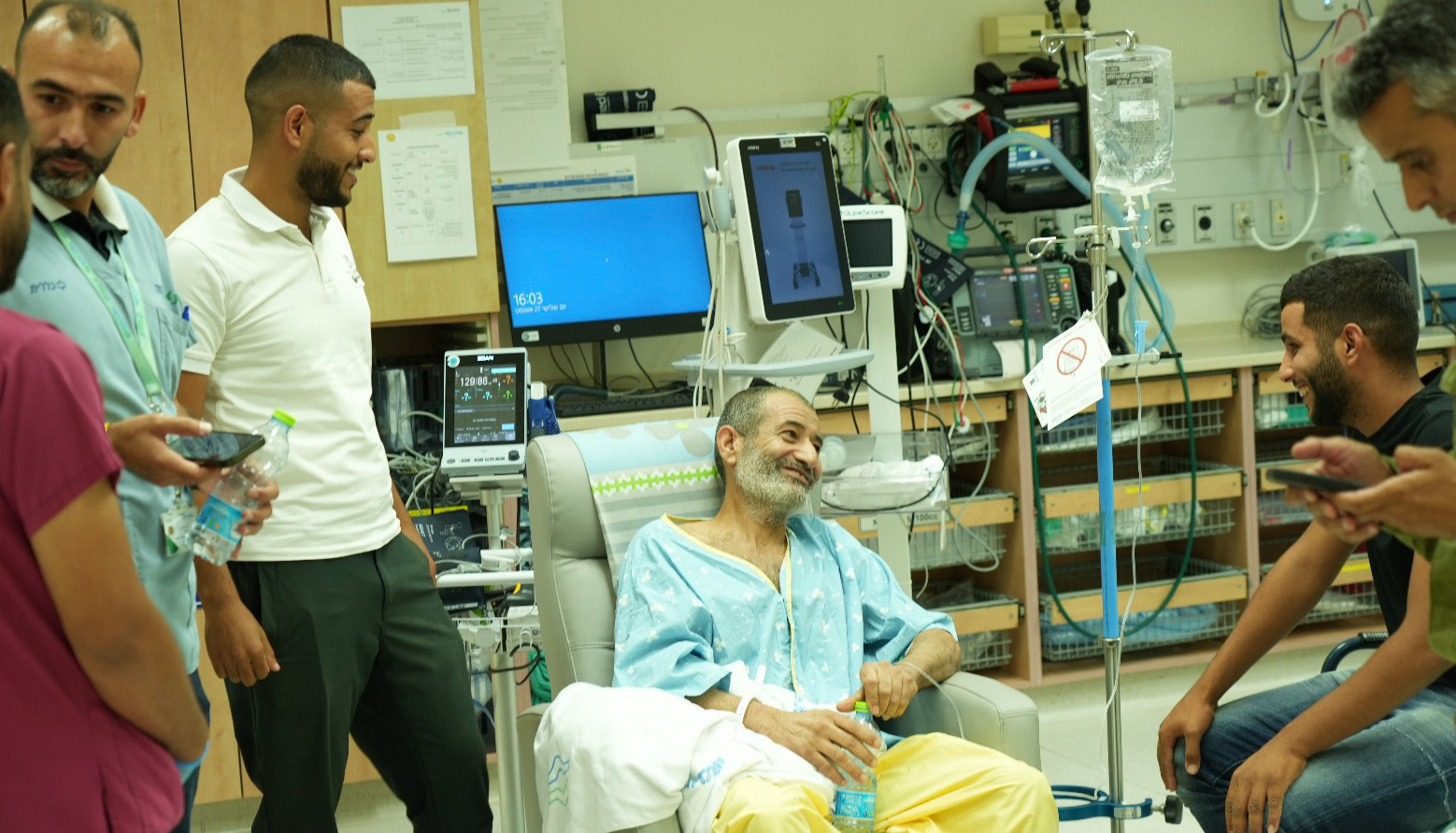 Smiling man in hospital gown surronded by happy men