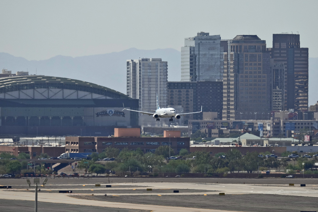 Downtown Phoenix is obscured by heat ripples as a jet lands at Sky Harbor International Airport