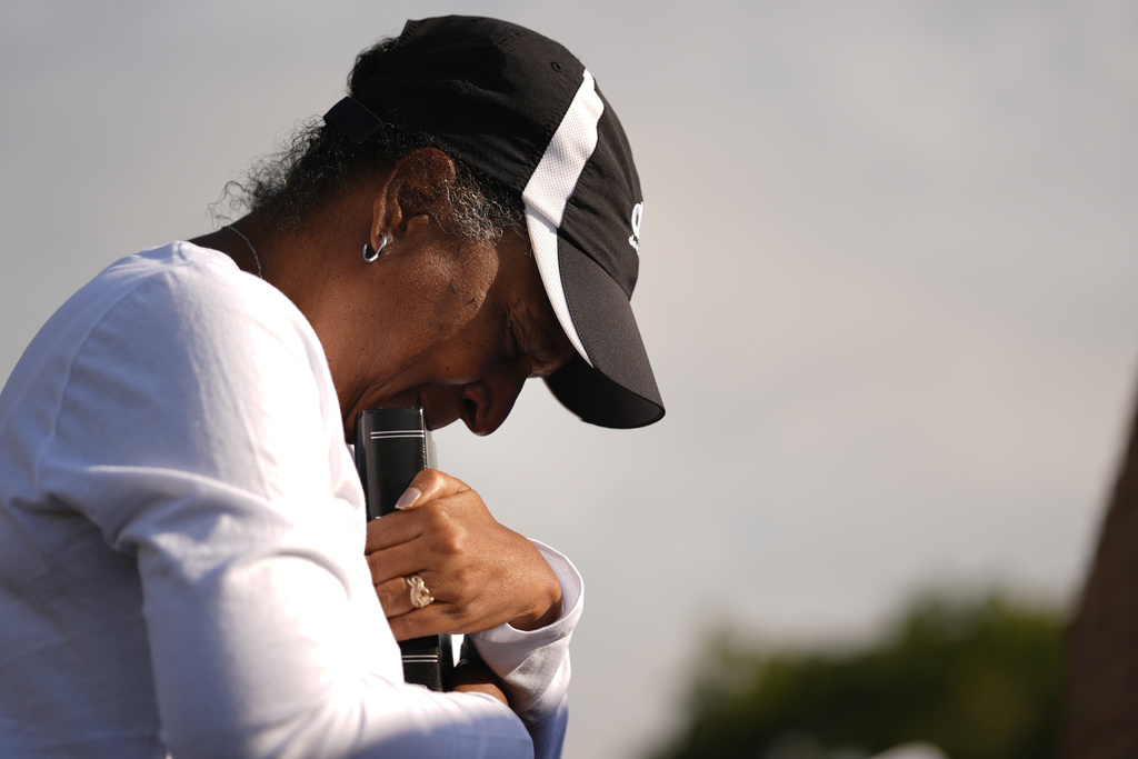 Chimain Douglas, of Grayson, Ga., holds a Bible as she cries near Apalachee High School