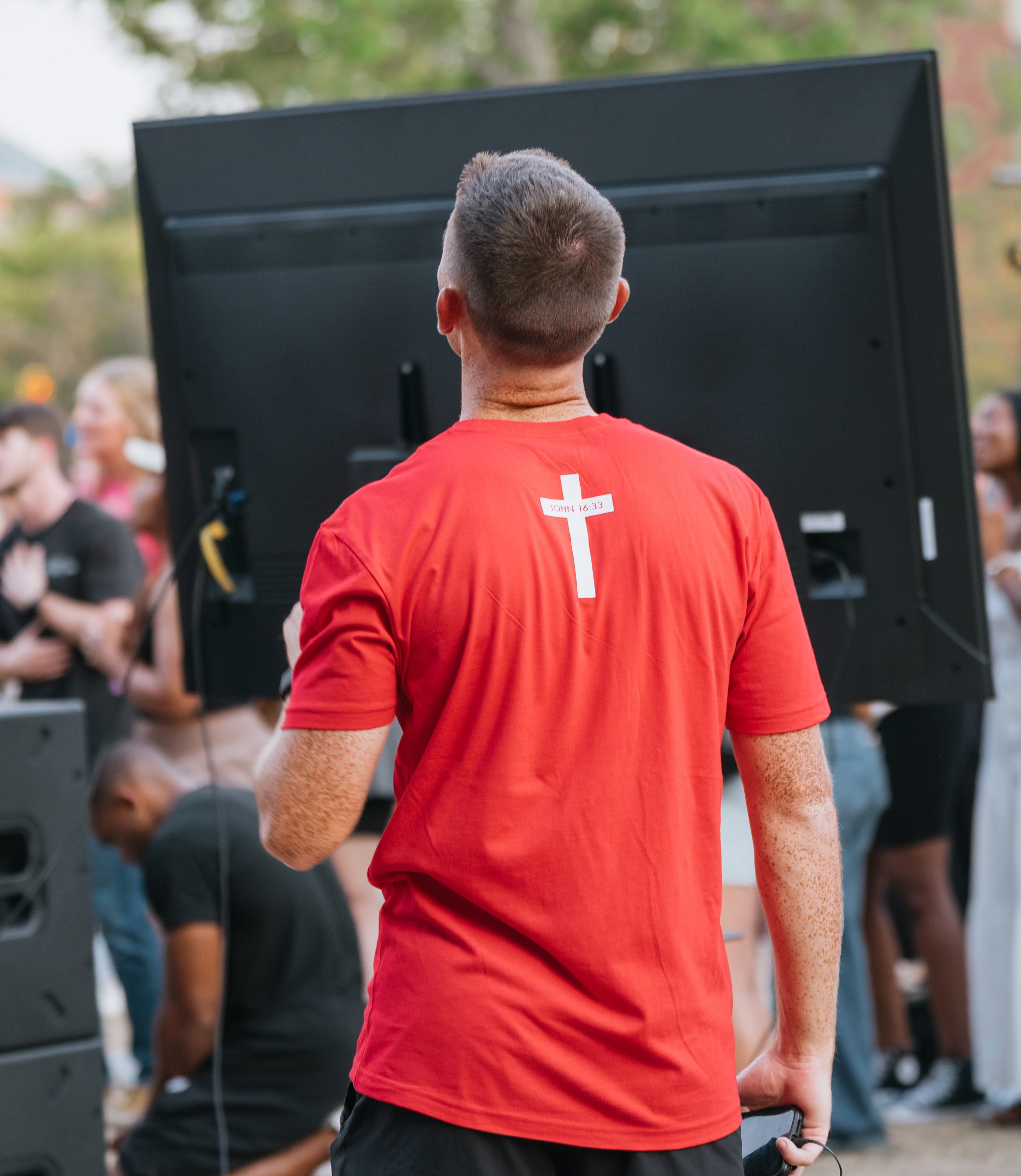 Young man in red t-shirt with white cross on it