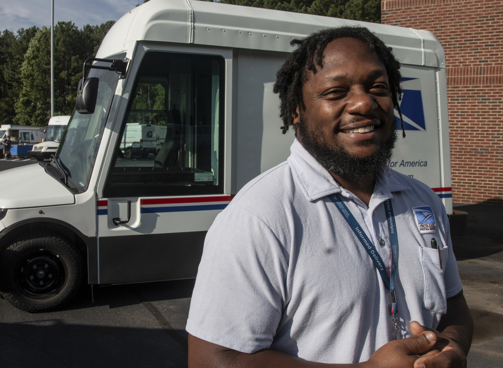 U.S. Postal Service delivery driver Richard Burton stands in the work lot of a postal facility in Athens, Ga., Thursday, Sept. 5, 2024.