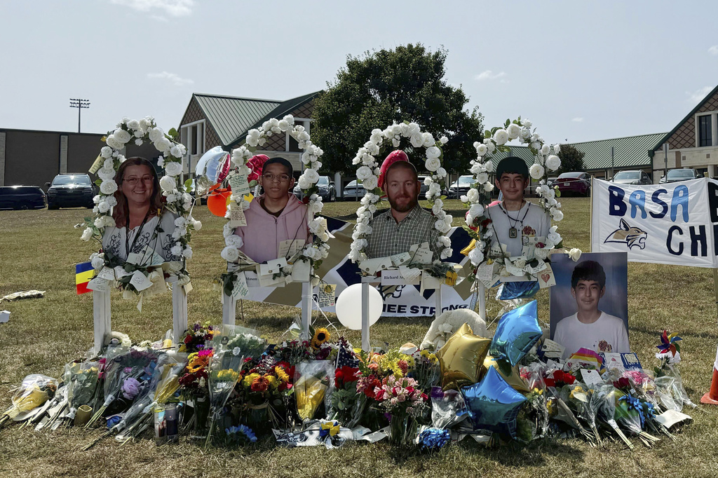 A poster with images of shooting victims from left, Cristina Irimie, Mason Schermerhorn, Richard Aspinwall and Christian Angulo is displayed at a memorial outside Apalachee High School