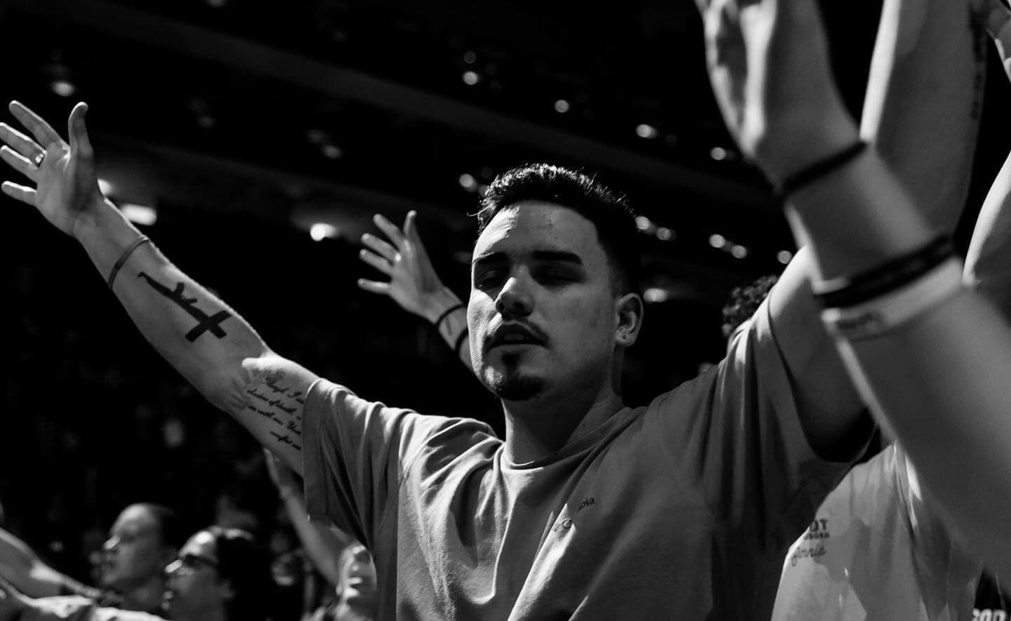 Young man with arms raised in worship