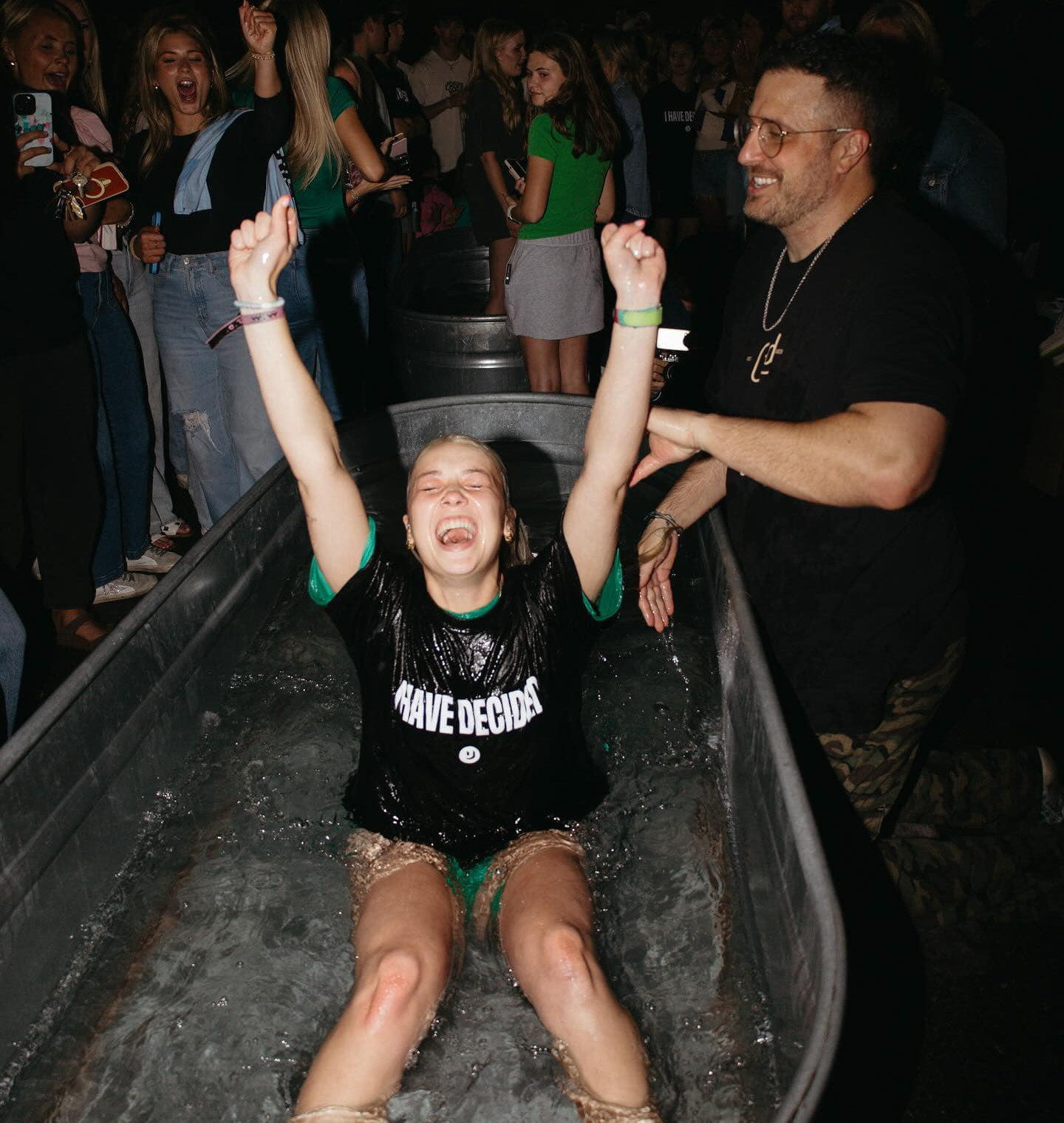 young girl with arms up in a water trough