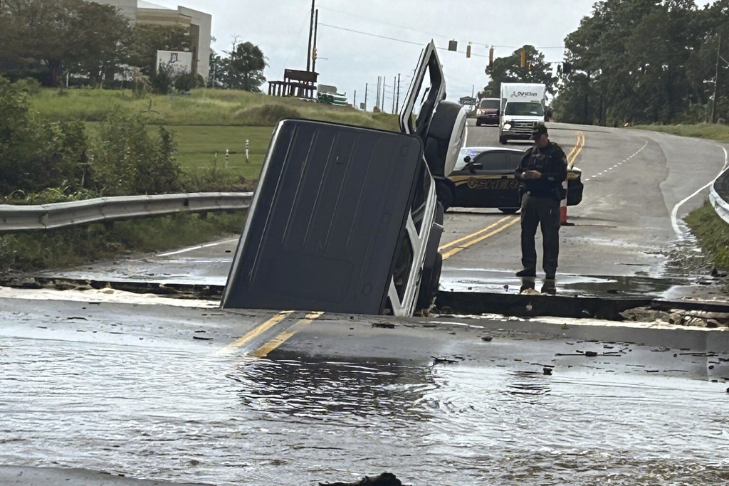 Police officer checking on a vehicle that fell into a sinkhole on a highway in Brunswick County, N.C.