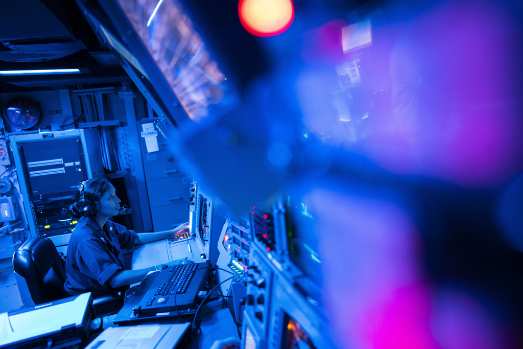 Crew members work in the combat information center of the Arleigh Burke-class guided missile destroyer USS Laboon during a deployment in the Red Sea