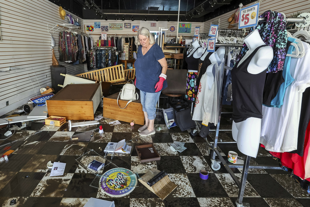 Jill Rice looks over the damage to her store caused by flooding from Hurricane Helene in Gulfport, Fla.