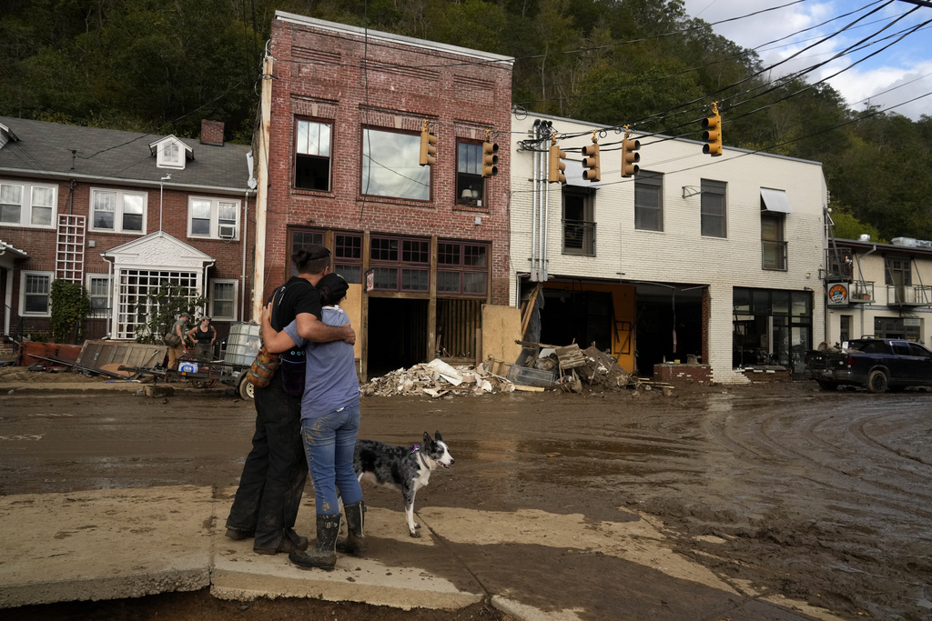 Resident Anne Schneider, right, hugs her friend Eddy Sampson as they survey damage left in the wake of Hurricane Helene in Marshall, N.C.