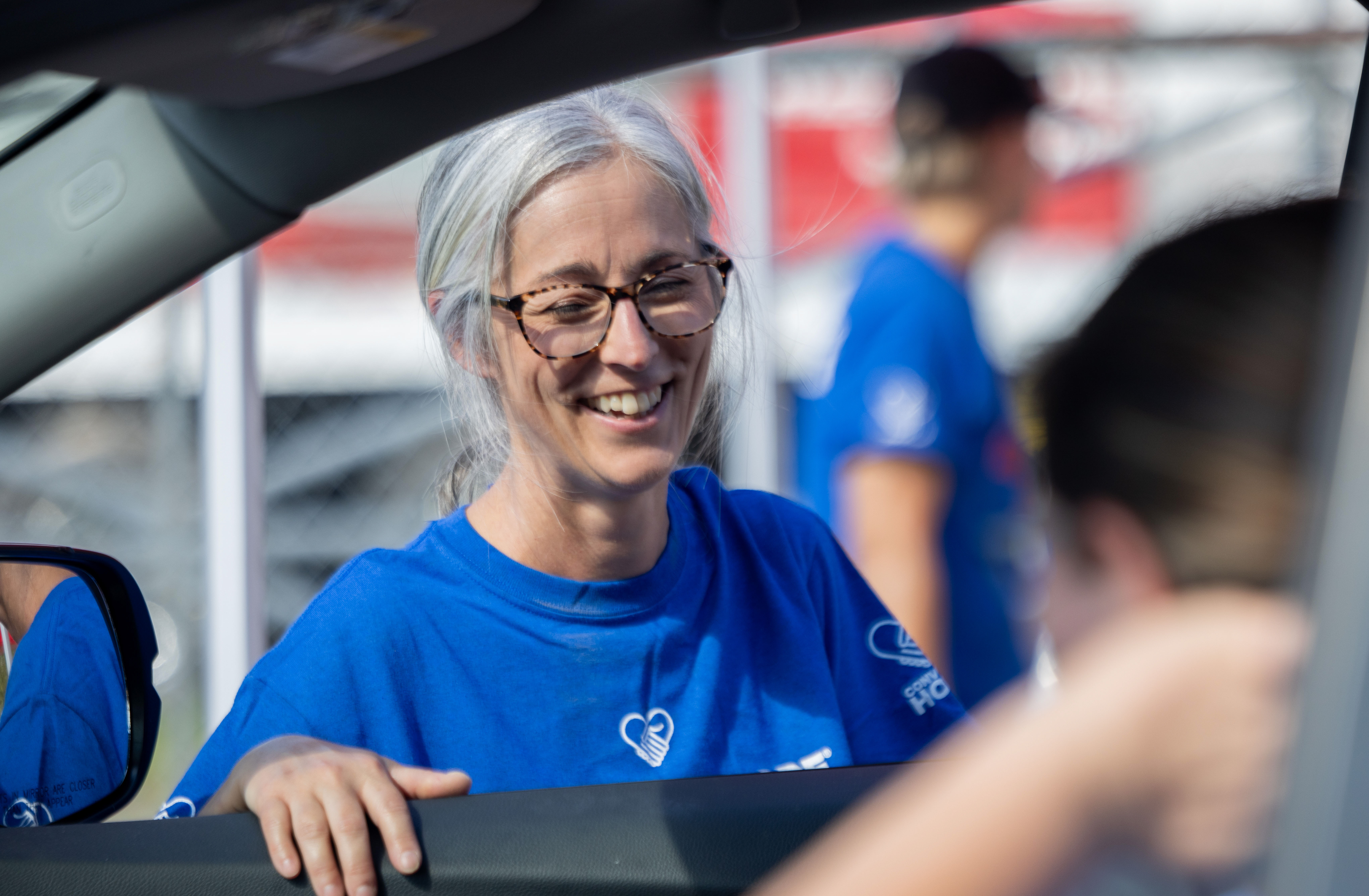 Woman smiling from outside of a car