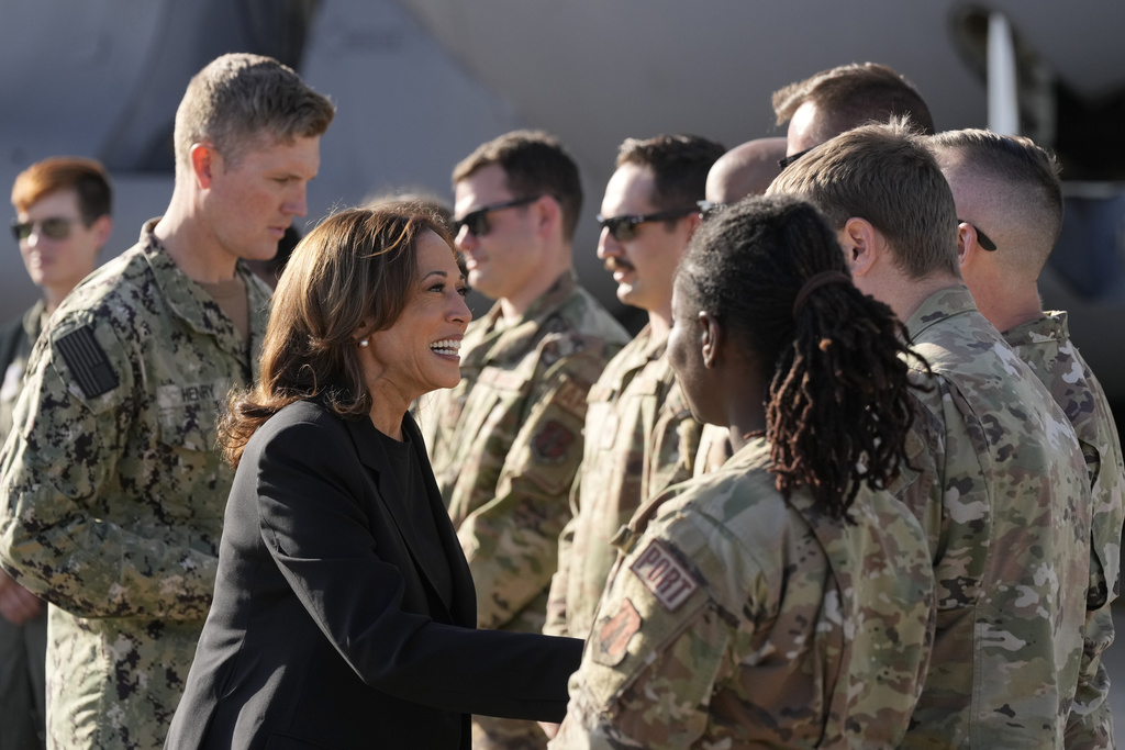 Vice President Kamala Harris greets members of the military near a C-17 cargo plane after receiving a briefing on the damage from Hurricane Helene