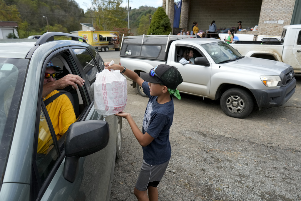 Benny Crawford 11, hands out free meals at a food and supply distribution center in Vilas, N.C.