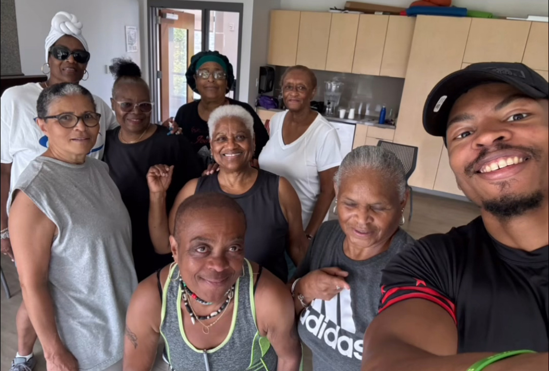 Young man smiling with 8 seniors