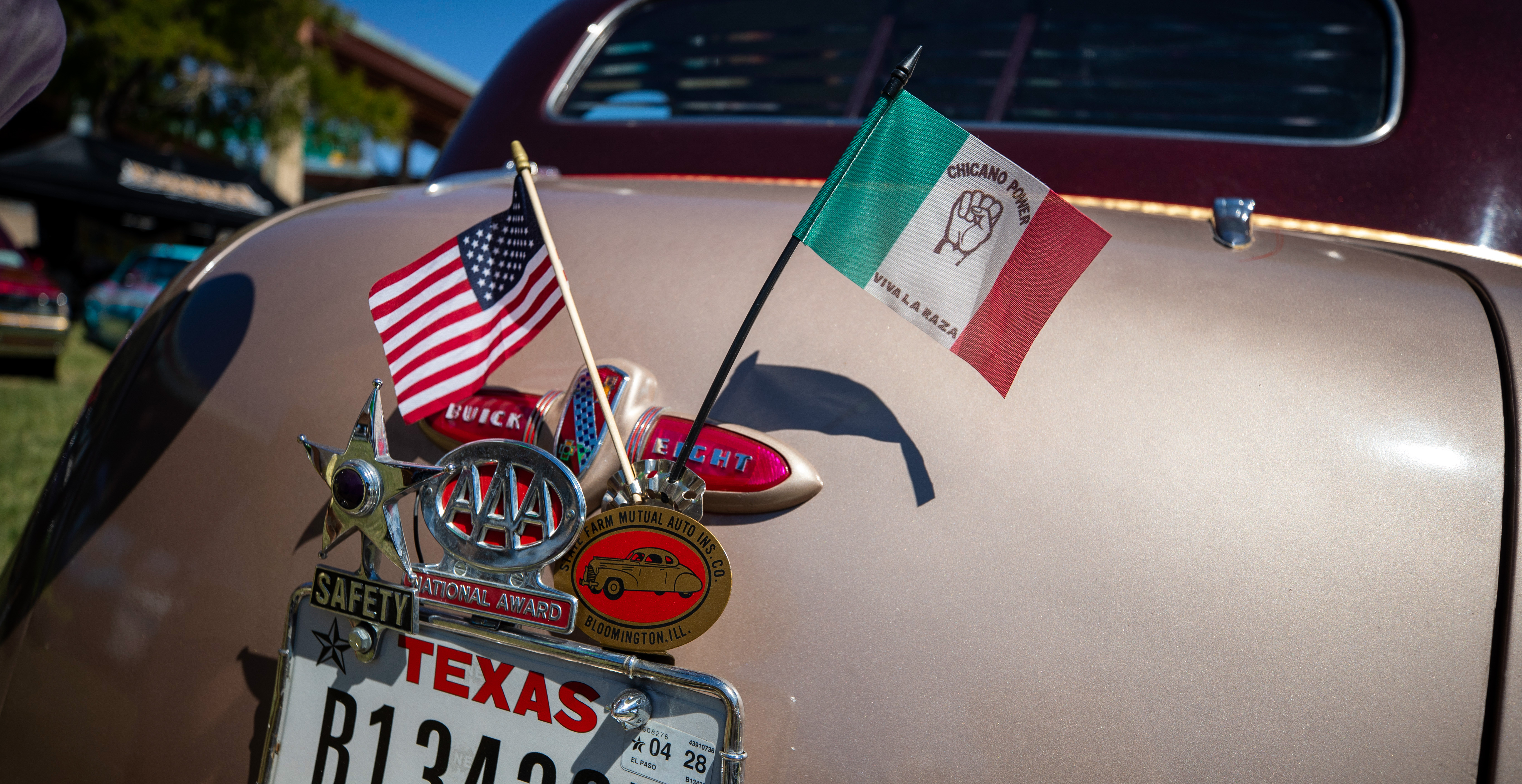 Lowrider car with American and Mexican flags