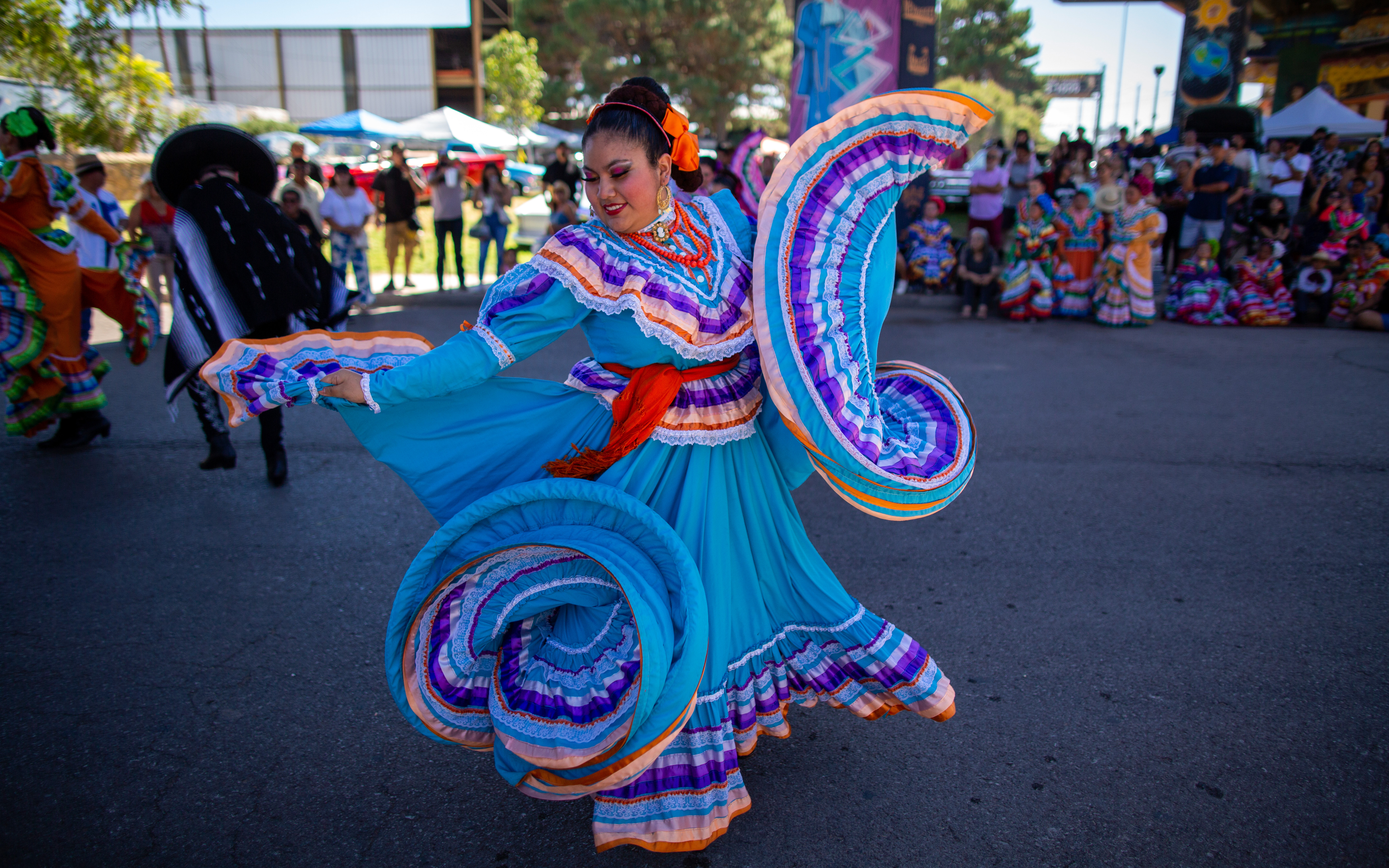 Woman dancing with a very bright blue and purple and orange dress