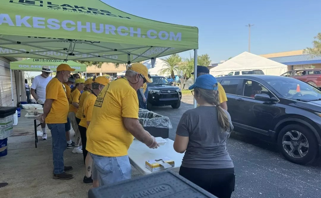 Yellow-shirted volunteers serving food to people in their cars