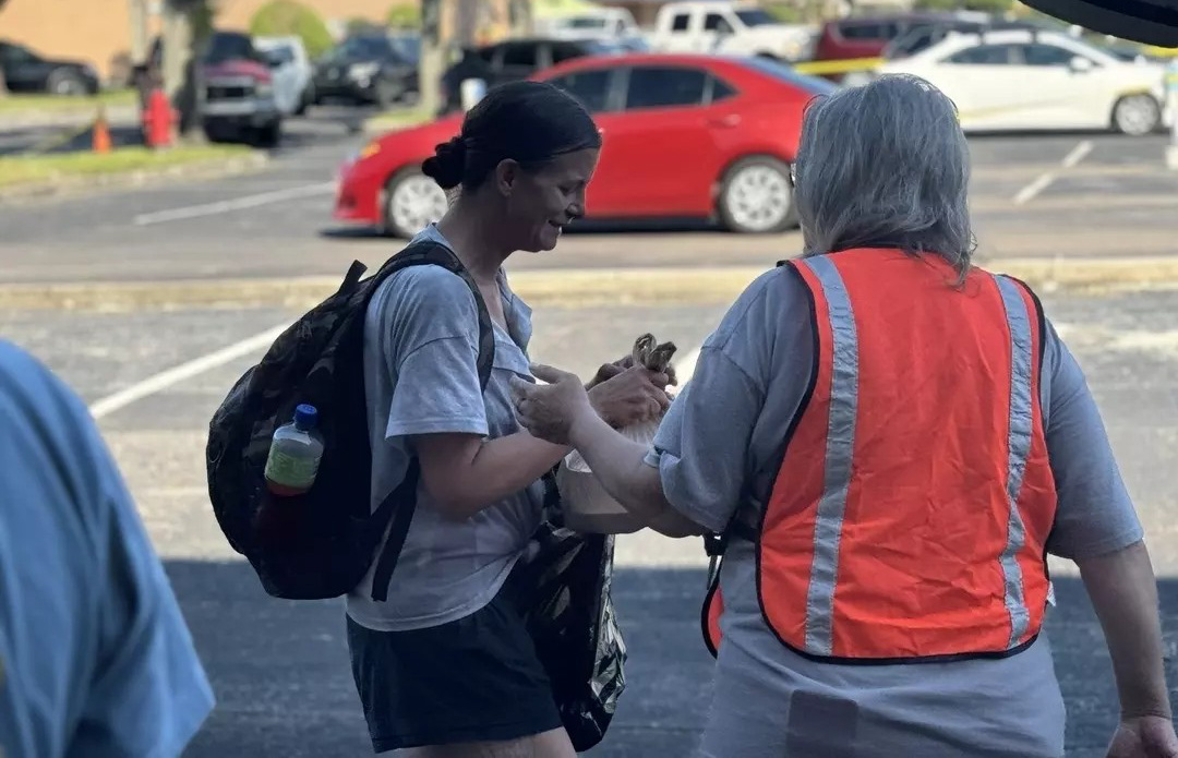 Woman crying with volunteer in the parking lot