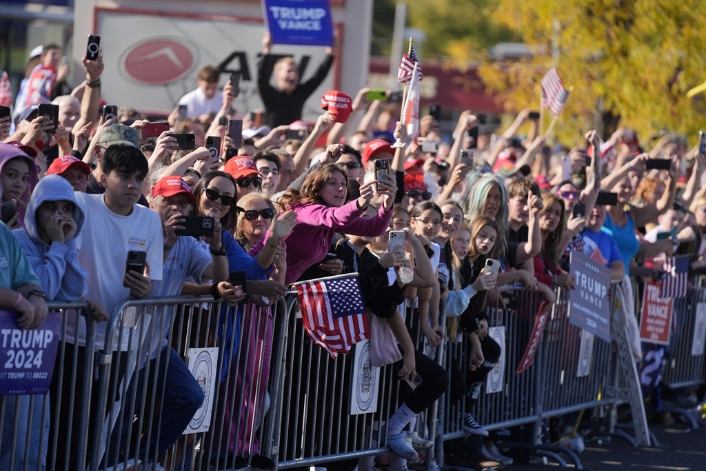 Supporters of Republican presidential nominee former President Donald Trump cheer outside of a McDonald