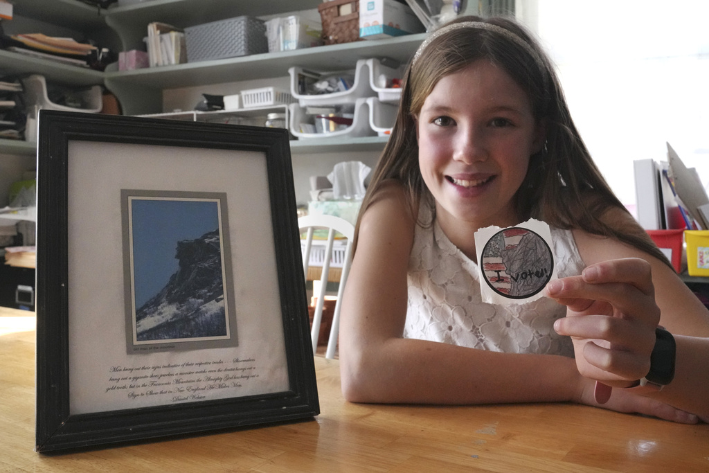 Ten-year-old Grace, of Milton, N.H. shows her contest winning "I Voted" sticker in her homeschool classroom, Thursday, Oct. 31, 2024, in Milton. Grace