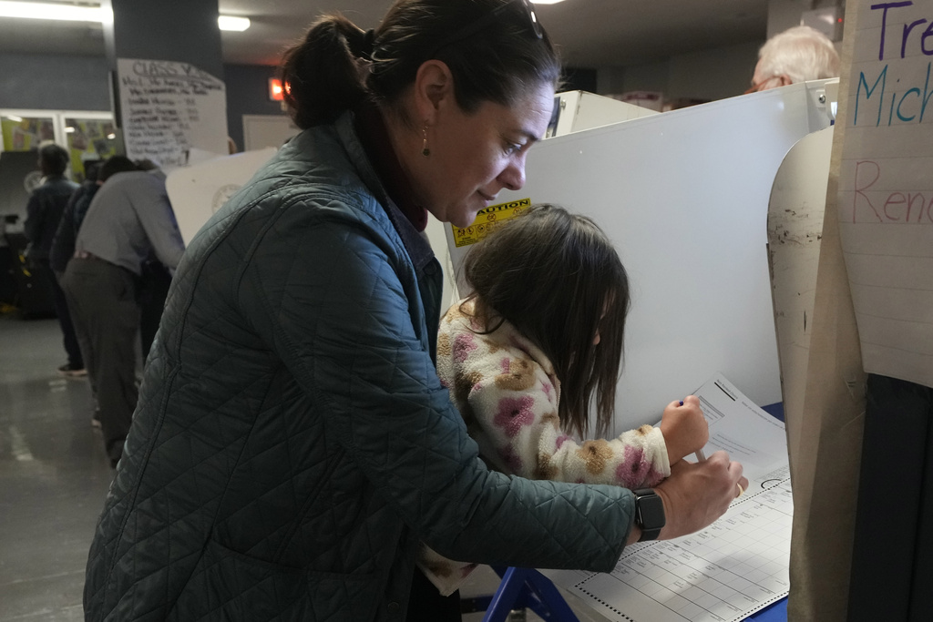 Vesta Avery, 2, helps her mother Alexis Taylor mark her ballot at P.S. M811, The Mickey Mantle School, in New York