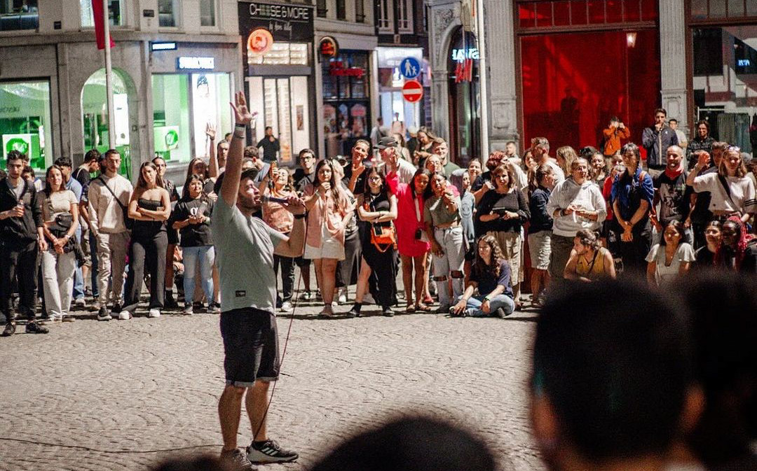 Man preaching in the middle of a circle of young people in a European city