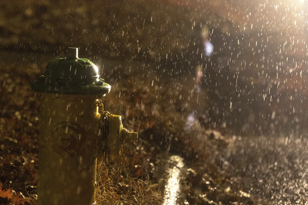 Headlights from a stranded motorist highlight freezing rain that coated surfaces in Omaha, Neb.