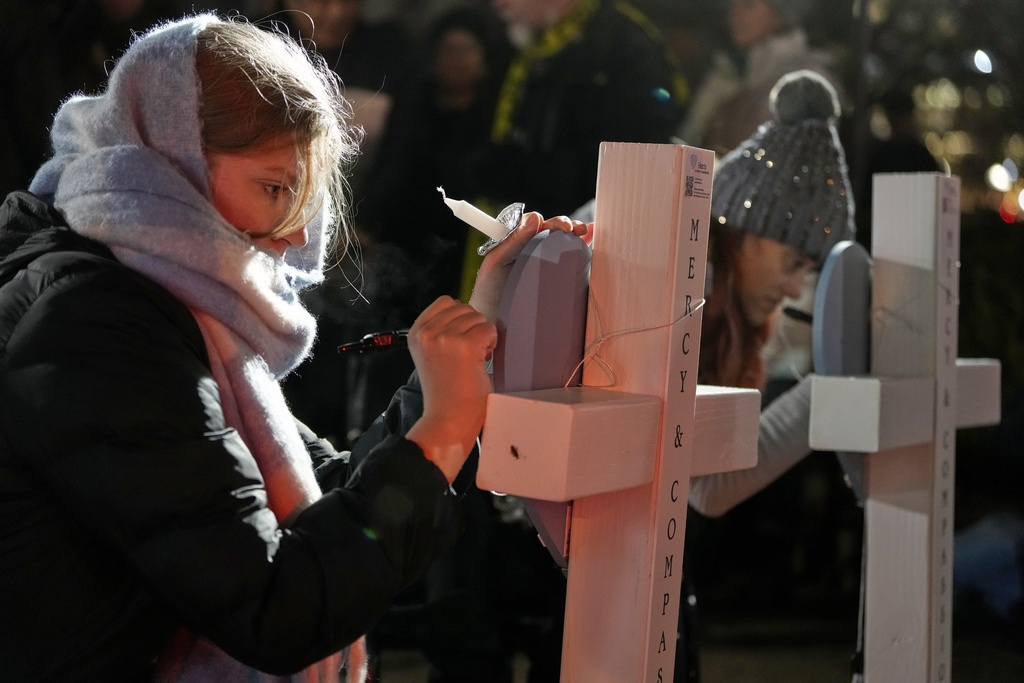 Supporters sign crosses during a candlelight vigil 