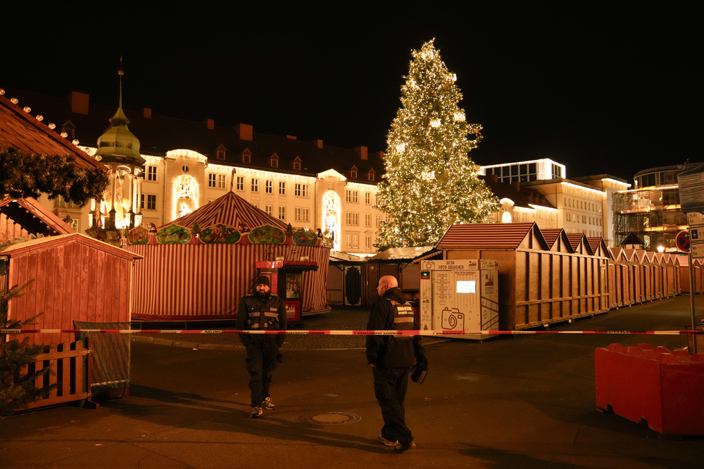 Security guards stand in front of a cordoned-off Christmas Market after a car crashed into a crowd of people, in Magdeburg, Germany