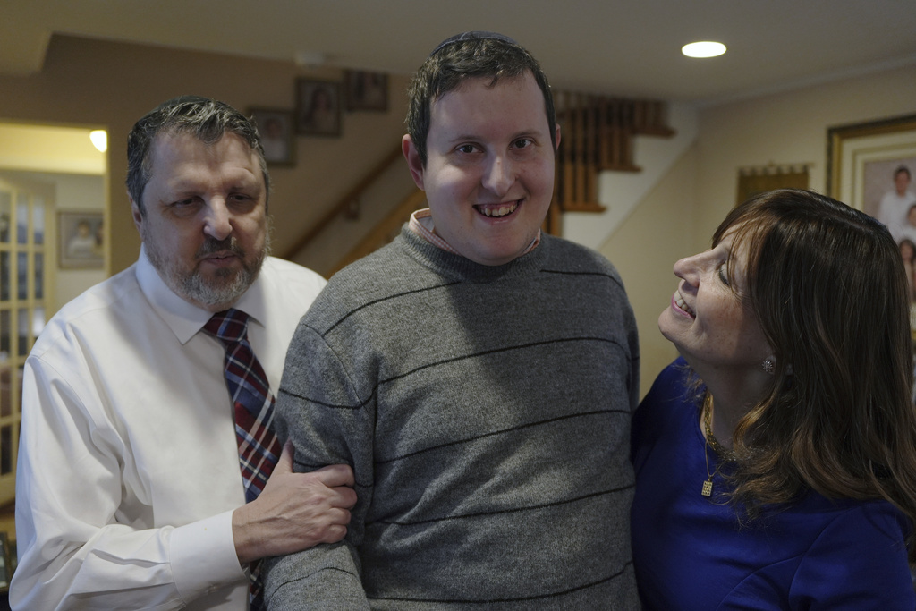 Dov Marcus smiles flanked by his parents, Robert Marcus and Debbie Marcus, in Teaneck, N.J.