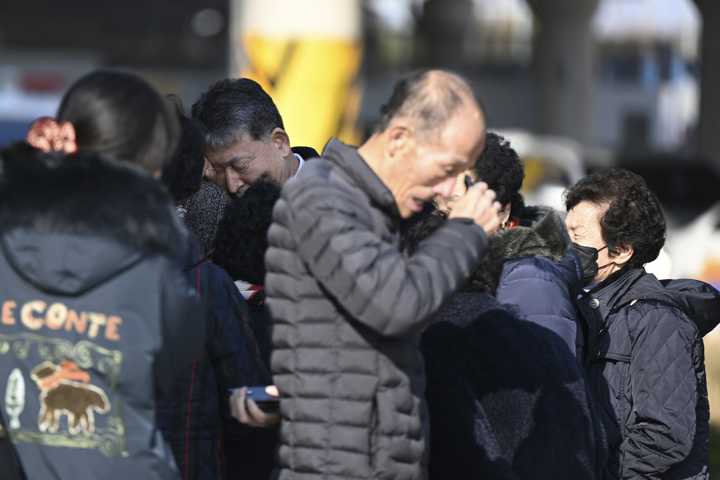 Family members of the passengers on a plane which burst into flames, weep at the Muan International Airport